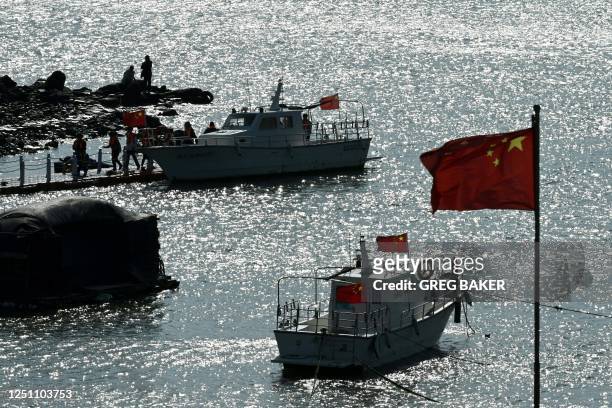 Passengers disembark from a tourist boat in a harbour on Pingtan island, opposite Taiwan, in Chinas southeast Fujian province on April 9, 2023. -...