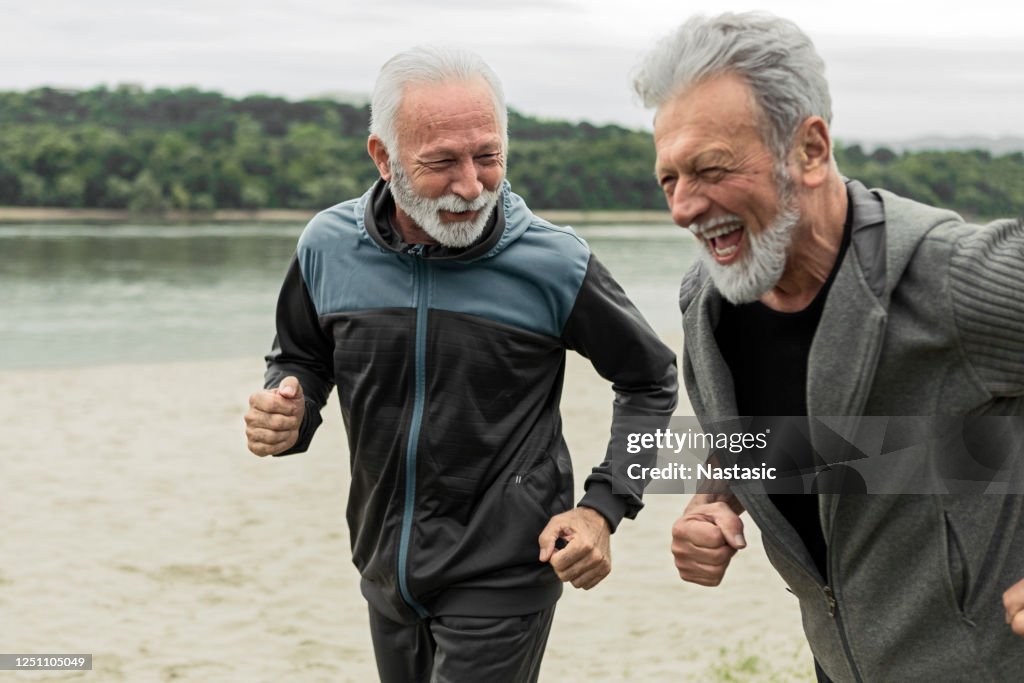 Two senior friends running together
