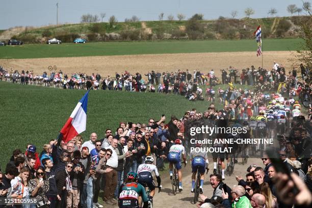 The pack of riders cycles over a cobblestone sector near Troisvilles, northern France, during the 120th edition of the Paris-Roubaix one-day classic...