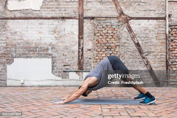 young man doing yoga outdoors, social distancing concept - yogi stock pictures, royalty-free photos & images