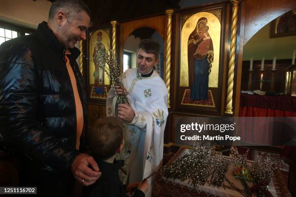 Father Bogdan hands out blessed branches of pussy willow to members of his congregation at a Palm Sunday service at St Olgas Ukranian church on April...