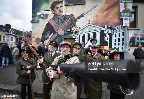 Republicans dressed in vintage themed military uniforms pose in front of a 1916 Easter Rising mural in RPG Avenue before taking part in a...