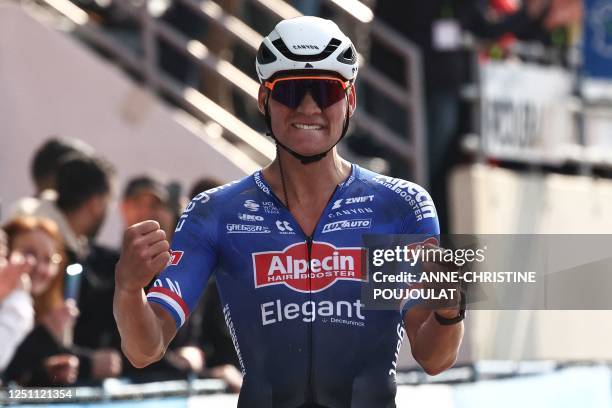 Alpecin-Deceuninck team's Dutch rider Mathieu Van Der Poel celebrates as he cycles to the finish line to win the 120th edition of the Paris-Roubaix...