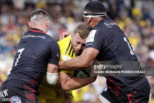 La Rochelle's French hooker Pierre Bourgarit is tackled by Saracens' English prop Mako Vunipola and Saracens' English flanker Ben Earl during the...