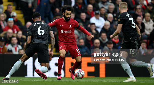 Liverpool's Egyptian striker Mohamed Salah vies with Arsenal's Brazilian defender Gabriel Magalhaes and Arsenal's Ukrainian defender Oleksandr...
