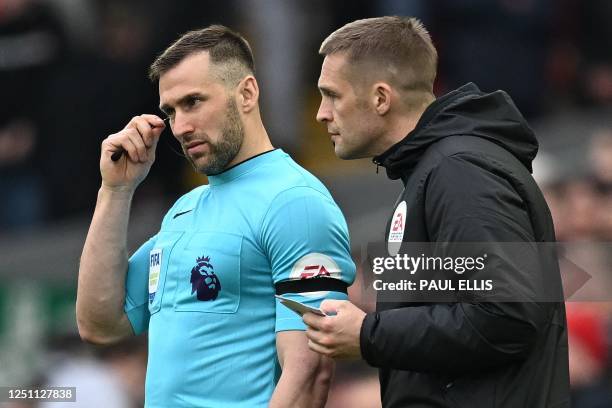 Fourth Official Craig Pawson talks to assistant referee and linesman Assistant Referee Constantine Hatzidakis during the English Premier League...