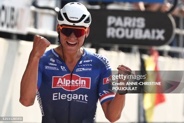 Alpecin-Deceuninck team's Dutch rider Mathieu Van Der Poel celebrates as he cycles to the finish line to win the 120th edition of the Paris-Roubaix...