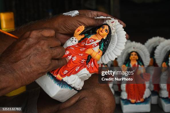 Devi Person A person is coloring the idols of the Hindu god Devi Laxmi ahead of ...