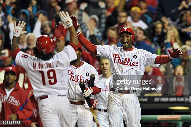 John Mayberry Jr. #15 of the Philadelphia Phillies cheers for teammate Michael Martinez as he crosses home for the game winning run on a Ryan Howard...