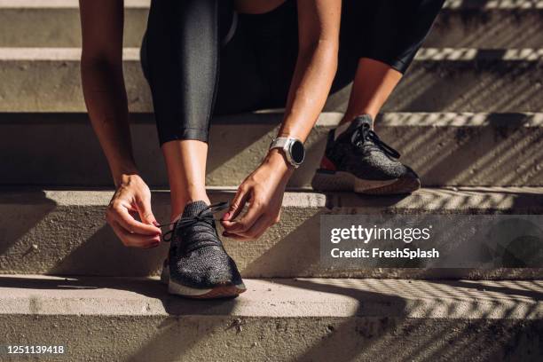 unkenntlich sportlerin binden schnürsenkel auf running sneakers, eine nahaufnahme - sportschuh stock-fotos und bilder