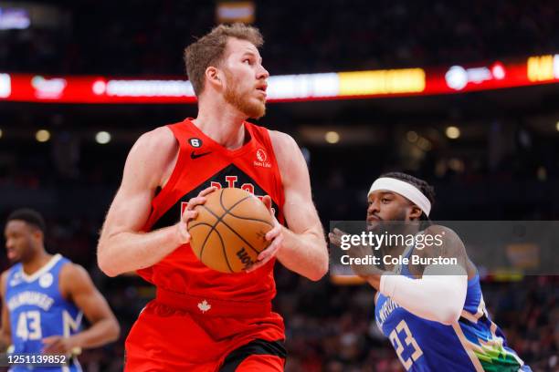 Jakob Poeltl of the Toronto Raptors dribbles against Wesley Matthews of the Milwaukee Bucks during the first half of their NBA game at Scotiabank...