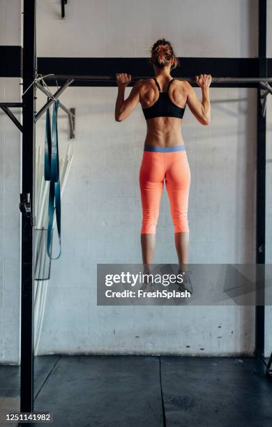 sportswoman doing pull ups - chin ups stock pictures, royalty-free photos & images