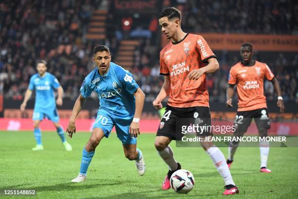 Marseille's Chilean forward Alexis Sanchez fights for the ball with Lorient's French midfielder Romain Faivre during the French L1 football match...