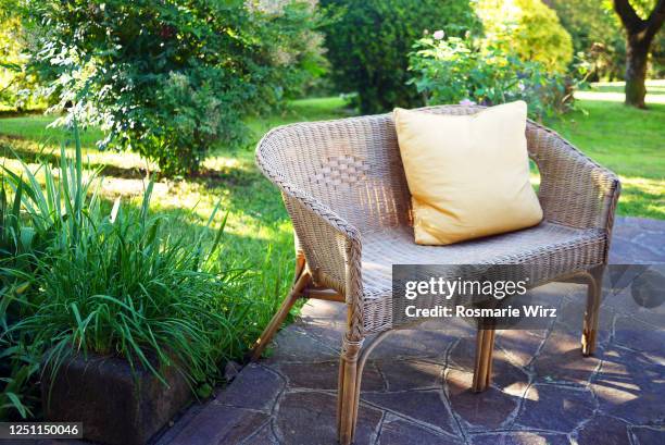 rattan bench with cushion in garden - wicker - fotografias e filmes do acervo