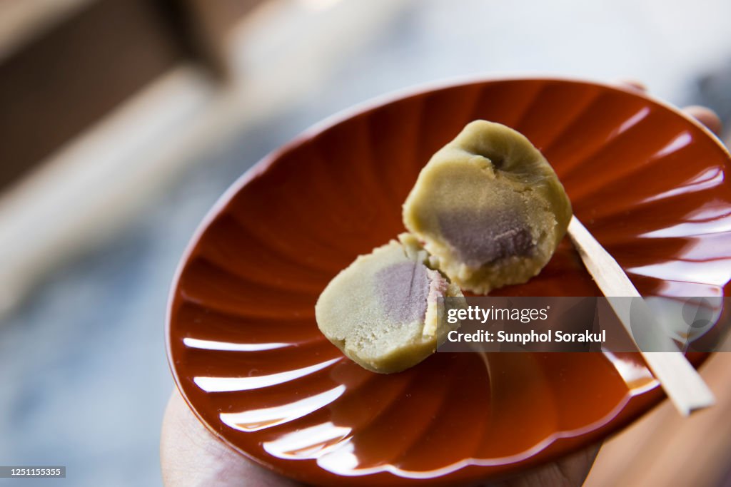 Japanese green wagashi cut in half showing the red bean filling