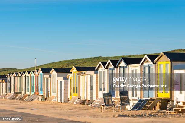 row of colorful cabins at the beach - netherlands beach stock pictures, royalty-free photos & images