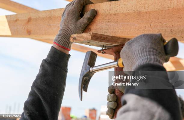 construction worker build a construction from wooden beams - dakdekker stockfoto's en -beelden