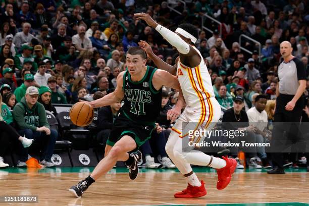 Payton Pritchard of the Boston Celtics dribbles the ball around Aaron Holiday of the Atlanta Hawks during the second half at TD Garden on April 9,...