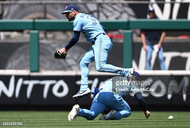 Kevin Kiermaier of the Toronto Blue Jays jumps over Daulton Varsho who lost a ball in the sun hit by Anthony Rendon of the Los Angeles Angels in the...