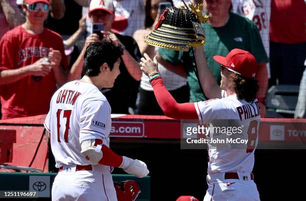 Shohei Ohtani of the Los Angeles Angels reacts before Brett Phillips puts a samurai helmet on his head as reward for a home run in the at Angel...