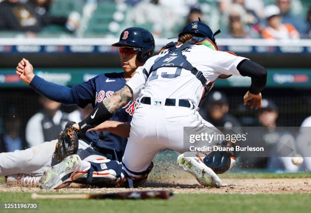 Catcher Eric Haase of the Detroit Tigers can't field the throw from left field with Rob Refsnyder of the Boston Red Sox scoring from third base on a...