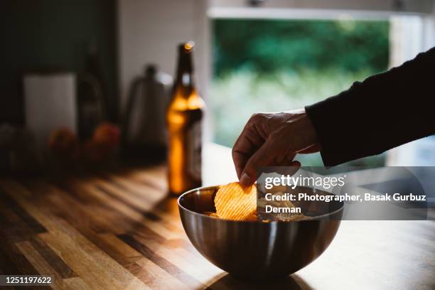 a man and potato chips, beer - salzige zwischenmahlzeit stock-fotos und bilder