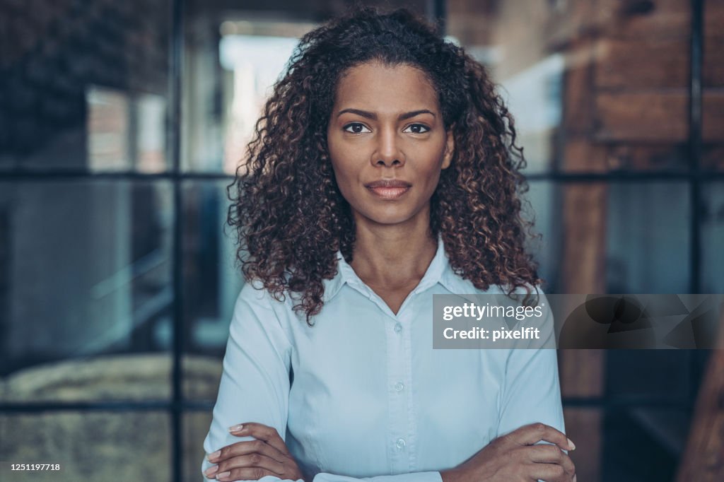 Ernsthafte junge afroamerikanische Geschäftsfrau