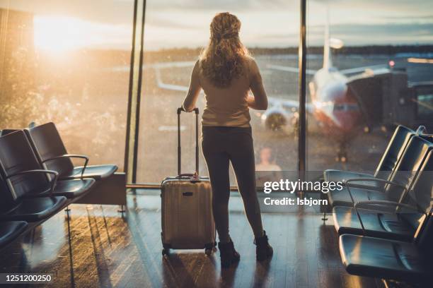 rear view of curly female at airport. - woman mid air stock pictures, royalty-free photos & images