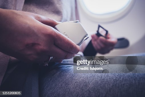 Mujer pasajero sujeta el cinturón de seguridad mientras está sentado en el avión para un vuelo seguro. Mujer pasajero sujeta el cinturón de seguridad mientras está sentado en el avión para un vuelo seguro.