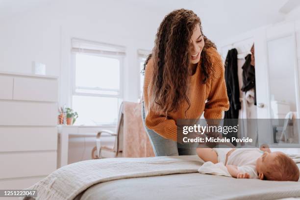 raza mixta madre latina cambiar su pañal bebé - pañal fotografías e imágenes de stock