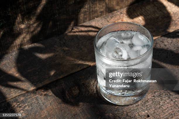 close up ice soda water on the glass cup with some shadow of tree - cup of water stockfoto's en -beelden