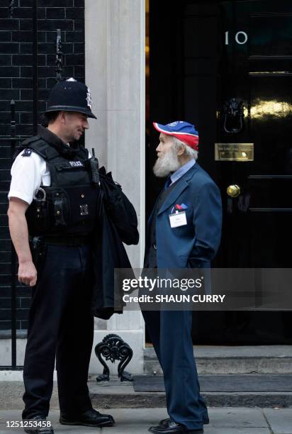 Buster Martin, one of Britain's oldest workers who claims he is 102 years old, talks with a policeman as he arrives at 10 Downing Street in London,...