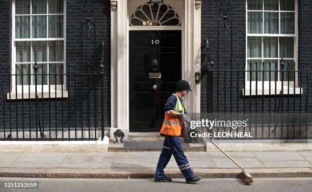 Street cleaner passes the front door of 10 Downing Street in London, on May 5 on the eve of a general election in Britain. Party leaders...