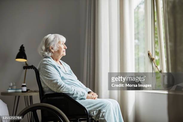 contemplated senior female sitting on wheelchair - 70 79 years stock pictures, royalty-free photos & images