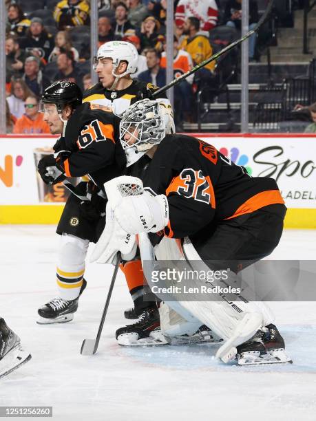 Goaltender Felix Sandstrom of the Philadelphia Flyers protects his crease as Justin Braun defends against Brad Marchand of the Boston Bruins at the...