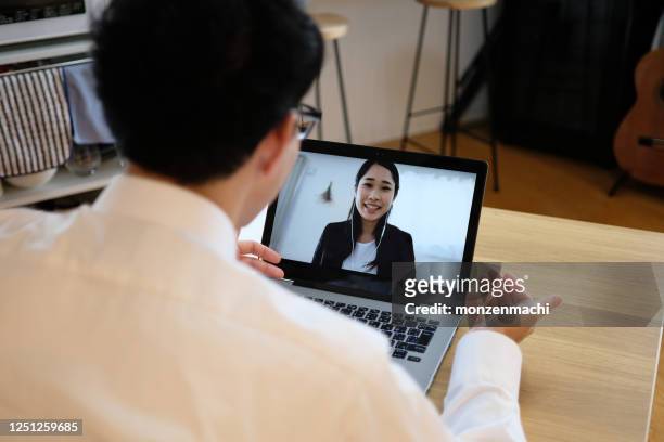 asian businessman talking to colleague on web meeting - internet stock pictures, royalty-free photos & images