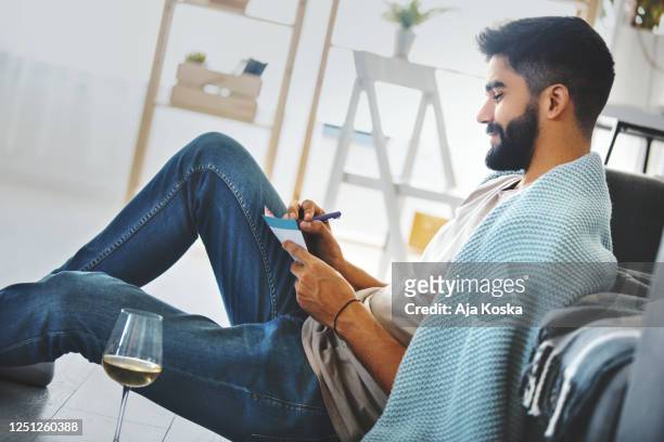 young man writing a letter. - love letter stock pictures, royalty-free photos & images