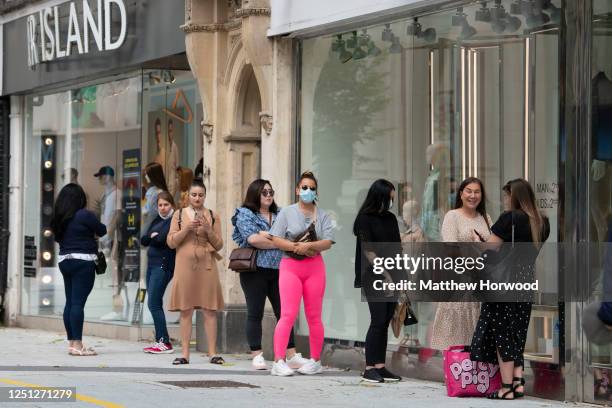 Shoppers queue outside River Island as Zara as non-essential shops open for the first time since the start of lockdown on June 22, 2020 in Cardiff,...