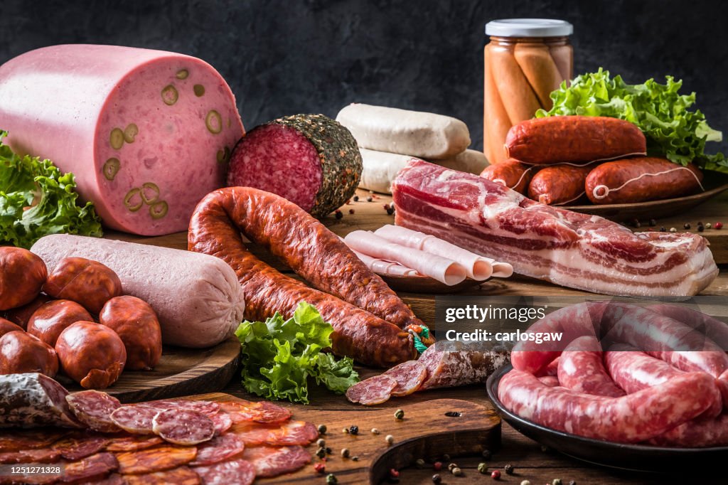 Various kinds of raw sausages on a rustic wooden table