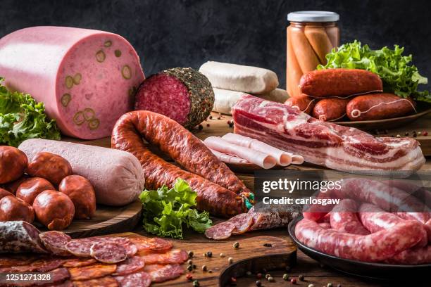 various kinds of raw sausages on a rustic wooden table - carne vermelha imagens e fotografias de stock