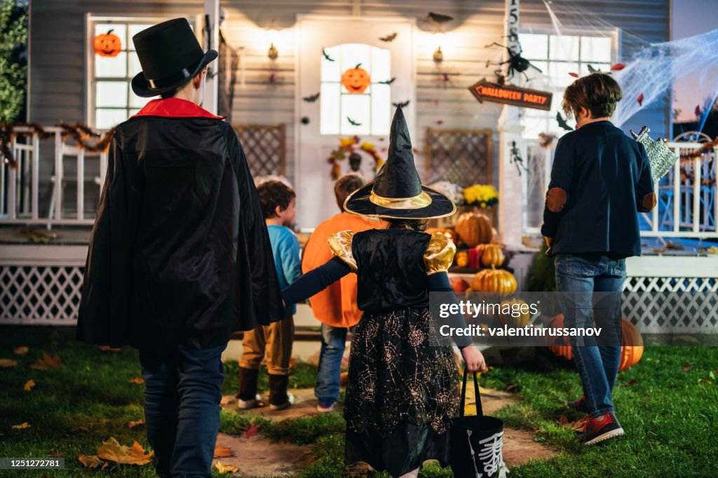 Young kids trick or treating at night during Halloween