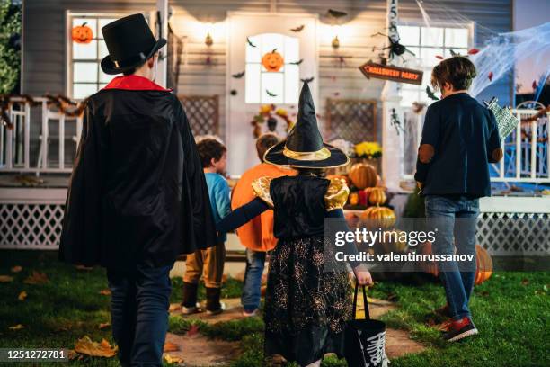 young kids trick or treating at night during halloween - trick or treat stock pictures, royalty-free photos & images