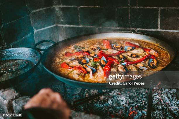 cooking spanish paella outdoors - las fallas stock-fotos und bilder