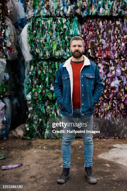 front view of man standing on landfill, waste management and environmental concept. - clothes landfill bildbanksfoton och bilder