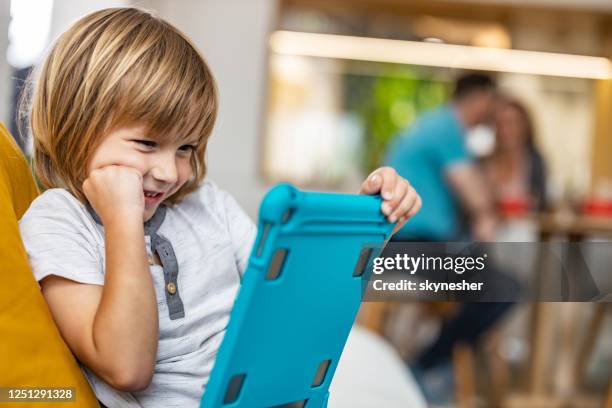 glücklicher junge beobachten cartoons auf touchpad zu hause. - child animated watching stock-fotos und bilder