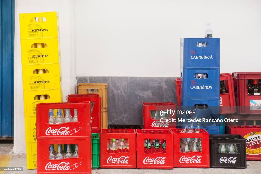 Heap of multicolored plastic crates outside a bar.