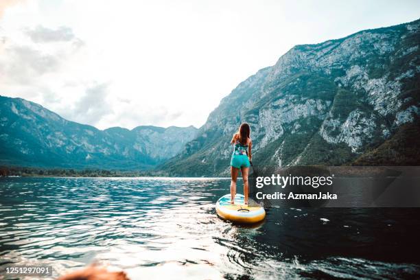 mid adult caucasian woman approaching on paddleboard - using a paddle stock pictures, royalty-free photos & images