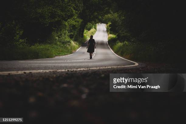 walking down an empty country road - killing stock-fotos und bilder