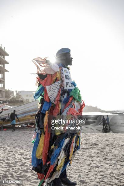 Year-old Senegalese environmental activist Modou Fall, known as "Plastic Man" looks at the beach as he takes a walk on the streets to alert people...