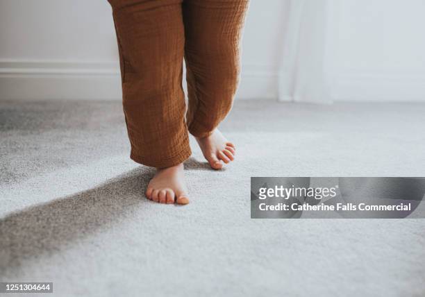 child's taking a step on grey thick pile carpet, casting shadow - carpet stock pictures, royalty-free photos & images